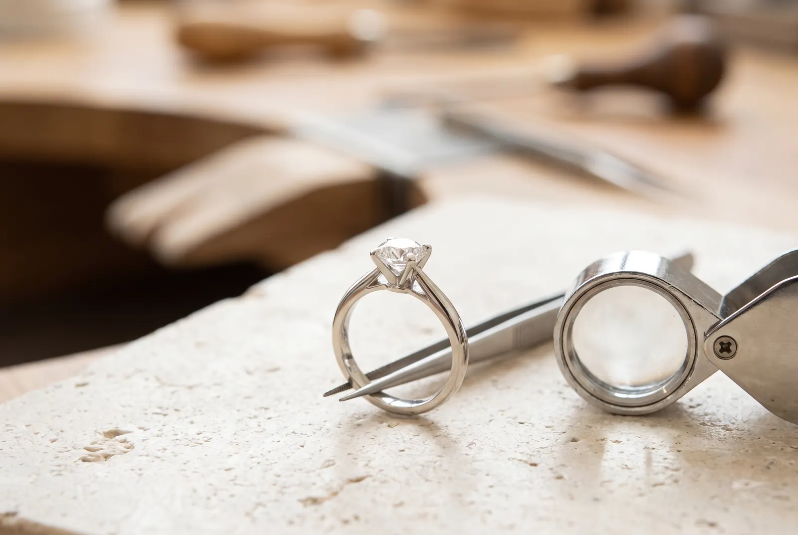 Diamantring wird mit Pinzette und Lupe geprüft – Diamantenankauf Köln